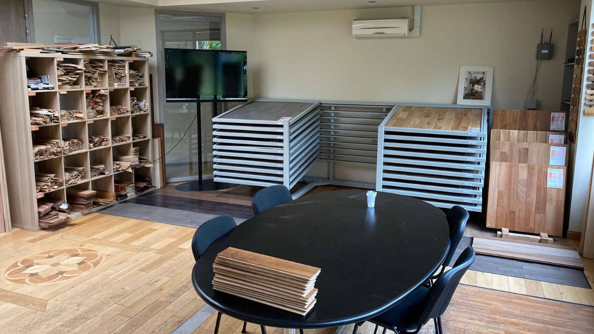 Showroom Les Moulures du Nord à Ennevelin, à 10 minutes de Lesquin : présentoirs de parquet, casiers d'échantillons de moulures et table de conseil